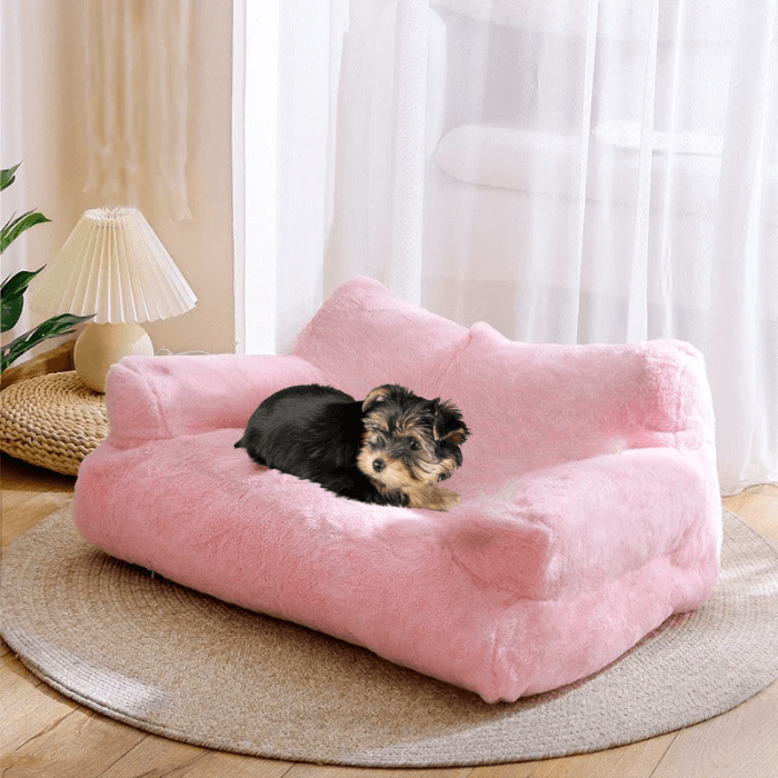  Na imagem, um cachorrinho pequeno e adorável descansa confortavelmente em uma cama de cachorro com design de sofá na cor rosa. A cama parece macia e confortável, ideal para um descanso ou uma soneca. O cenário sugere um ambiente caseiro, com a luz natural entrando pela janela e o piso de madeira, criando uma atmosfera aconchegante e acolhedora. É uma imagem que pode atrair donos de animais de estimação que desejam proporcionar um espaço próprio e confortável para seus amigos de quatro patas.