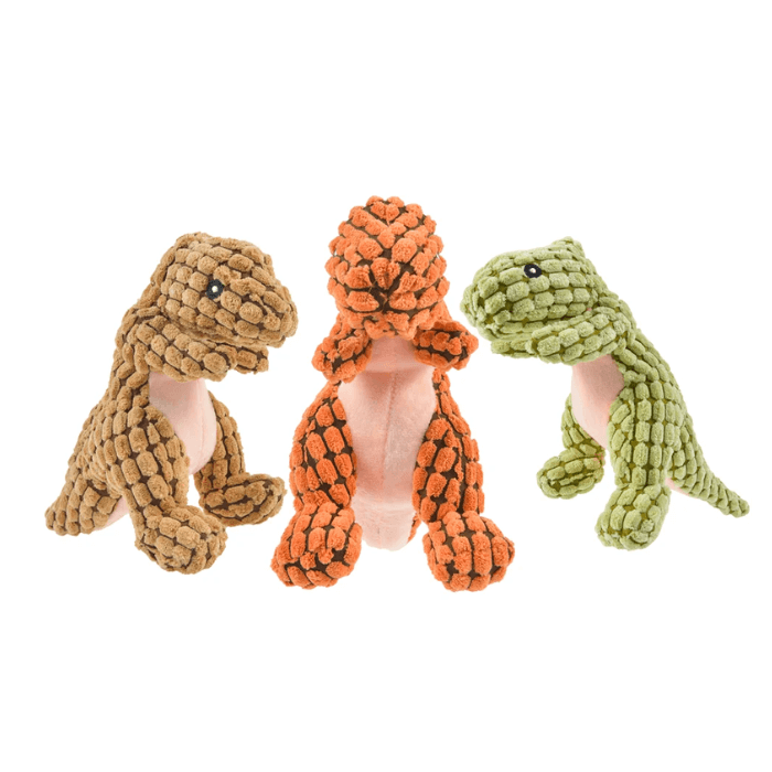 Coleção de três brinquedos de pelúcia para cachorro em forma de dinossauro Tiranossauro Rex, em cores diferentes, posicionados lado a lado. À esquerda, um dinossauro na cor bege; ao centro, um na cor laranja; e à direita, um na cor verde-oliva. Todos têm barrigas cor-de-rosa e olhos pretos bordados, com uma textura de tecido macio e saliente que é ideal para brincadeiras de morder e agarrar dos pets.